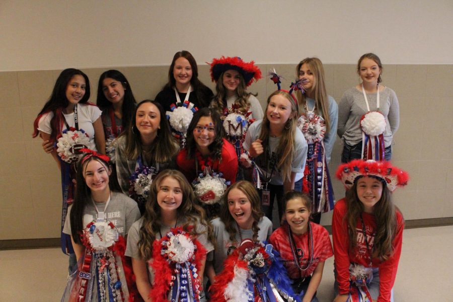 Students show off their Homecoming mums on Friday.