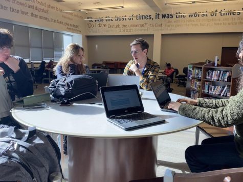 NaNoWriMo members sit down with librarian Collin Stephenson at the latest meeting. Kate Busse (12) and Juliana Trillo (12) have been planning out their stories and developing their characters.